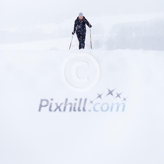 Cross-country skiing: young woman cross-country skiing on a snowy winter day Cross-country skiing: young woman cross-country skiing on a snowy winter day