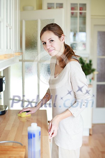Young woman doing housework, cleaning the kitchen Young woman doing housework, cleaning the kitchen