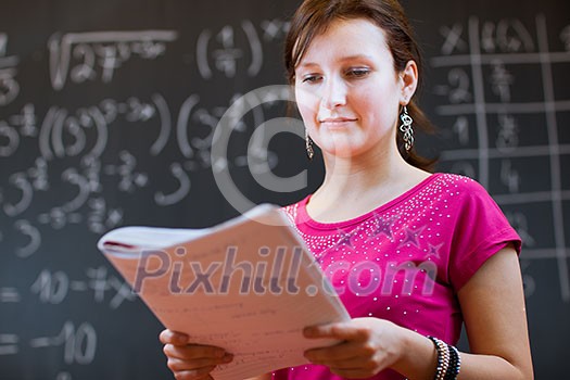 pretty young college student by the chalkboard/blackboard during a math class (color toned image) pretty young college student by the chalkboard/blackboard during a math class (color toned image)