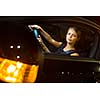 Driving a car at night - pretty, young woman driving her modern car at night, in a city (shallow DOF; color toned image)