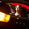 Driving a car at night - pretty, young woman driving her modern car at night, in a city (shallow DOF; color toned image)