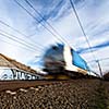 Fast train passing under a bridge on a lovely summer day (motion blurred image)