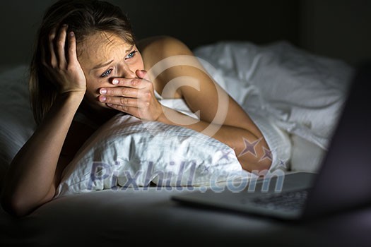 Pretty young woman watching something awful/sad on her laptop in bed Pretty young woman watching something awful/sad on her laptop in bed