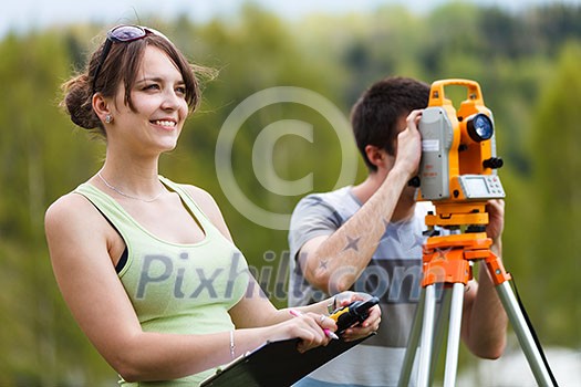 Two young land surveyors at work Two young land surveyors at work