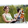 Two young land surveyors at work