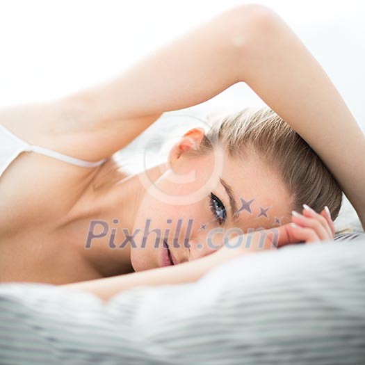 Attractive young woman in bed (shallow DOF; color toned image) Attractive young woman in bed (shallow DOF; color toned image)
