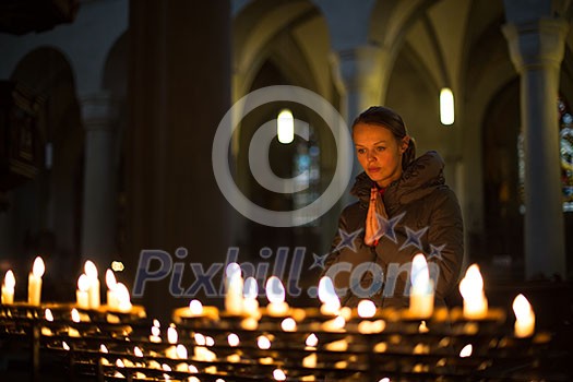 Young woman praying in a church Young woman praying in a church