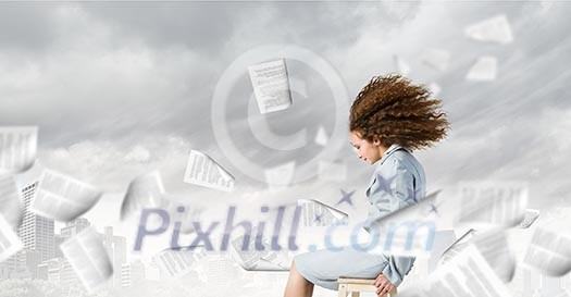 Young tired businesswoman with waving hair among flying documents Young tired businesswoman with waving hair among flying documents