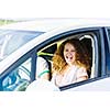 Young pretty woman driving car and leaning out of car window