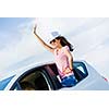 Young pretty woman leaning out of car window