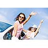 Young pretty women leaning out of car window