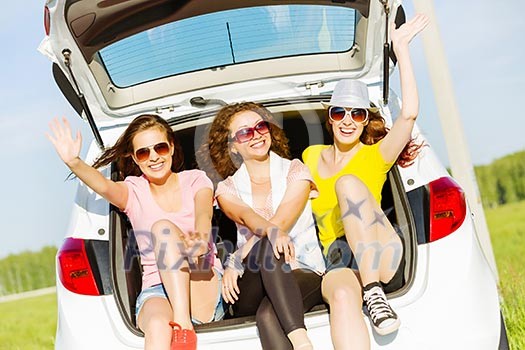 Three young pretty lady sitting in car boot Three young pretty lady sitting in car boot