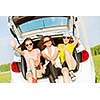 Three young pretty lady sitting in car boot