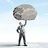 Powerful businessman holding huge stone above head