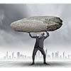 Powerful businessman holding huge stone above head