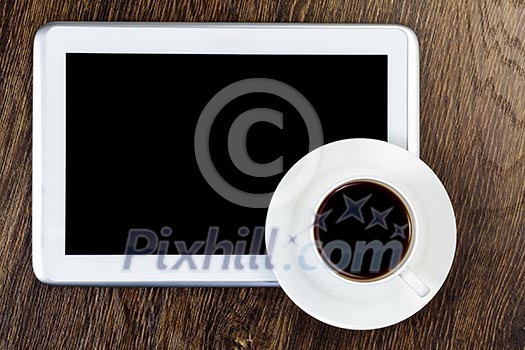 Tablet pc cup of coffee and notepad at table Tablet pc cup of coffee and notepad at table