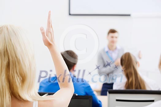 Young teacher in classroom standing in front of class Young teacher in classroom standing in front of class