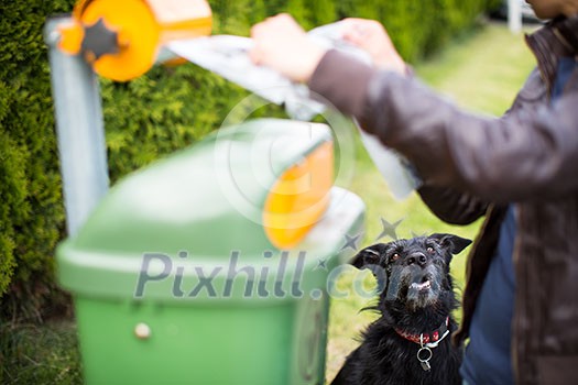 Do not let your dog faul! - Young woman grabbing a plastic bag in a park to tidy up after her dog later Do not let your dog faul! - Young woman grabbing a plastic bag in a park to tidy up after her dog later