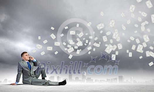 Image of young man sitting on floor and using mobile phone Image of young man sitting on floor and using mobile phone