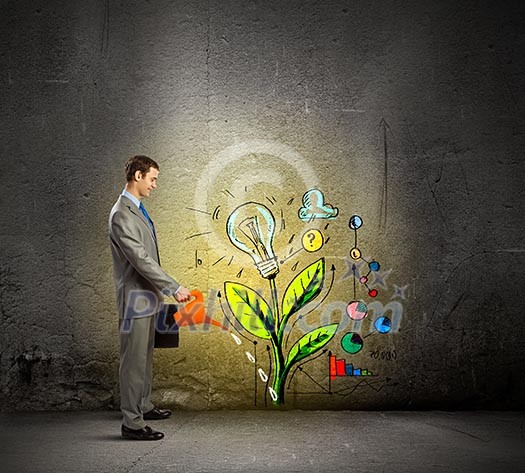 Image of businessman watering sprout with can Image of businessman watering sprout with can