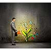Image of businessman watering sprout with can