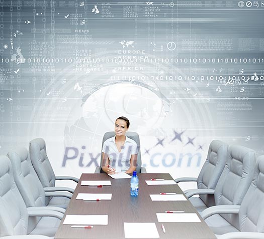 Young attractive businesswoman sitting at head of negotiating table Young attractive businesswoman sitting at head of negotiating table