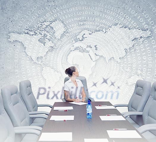 Young attractive businesswoman sitting at head of negotiating table Young attractive businesswoman sitting at head of negotiating table