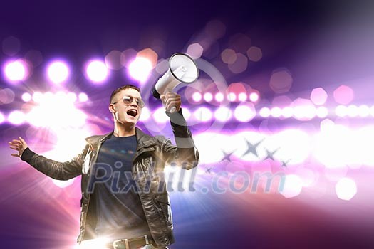 Image of young man musician singing in megaphone Image of young man musician singing in megaphone