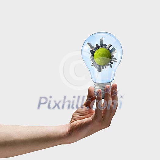 Image of human hand holding bulb with earth planet inside Image of human hand holding bulb with earth planet inside
