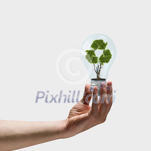 Image of human hand holding bulb with recycle symbol inside Image of human hand holding bulb with recycle symbol inside
