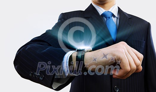 Businessman looking at wristwatch. Media technologies and innovations Businessman looking at wristwatch. Media technologies and innovations