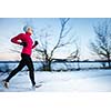 Young woman running outdoors on a cold winter day (motion blurred image)