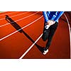 Young woman stretching before her run casts a shadow on the track