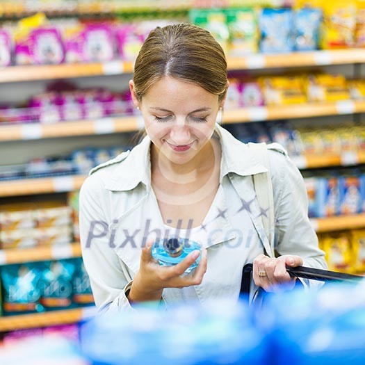 Beautiful young woman shopping in a grocery store/supermarket (color toned image) Beautiful young woman shopping in a grocery store/supermarket (color toned image)