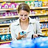 Beautiful young woman shopping in a grocery store/supermarket (color toned image)