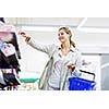 Beautiful young woman shopping in a grocery store/supermarket (color toned image)
