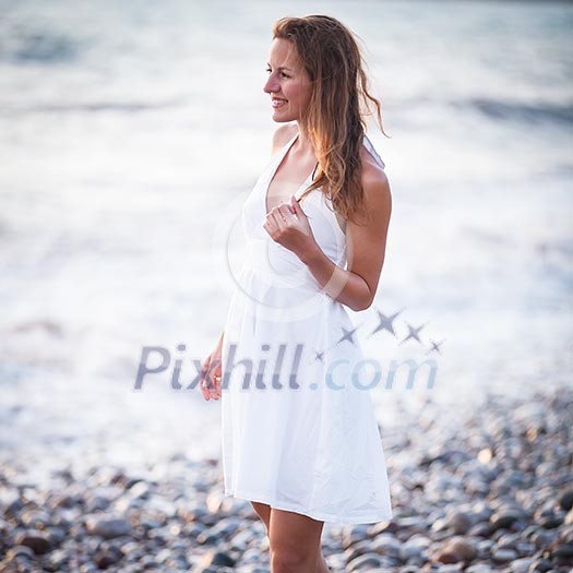 Young woman on the beach enjoying a warm summer evening Young woman on the beach enjoying a warm summer evening