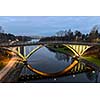 Bridge over calm river in evening lights