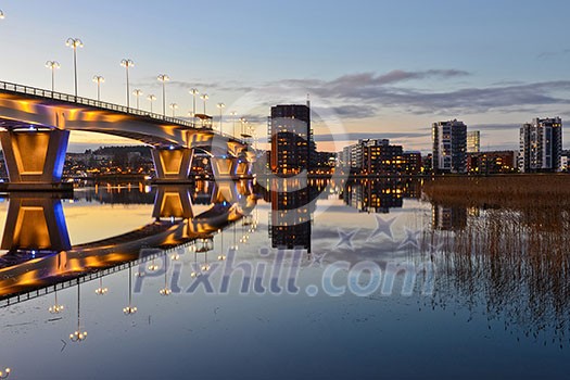 Apartment houses by lakeside and lighted bridge Apartment houses by lakeside and lighted bridge