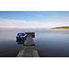 Blue boat by a wooden pier on a misty morning