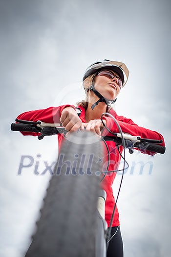 Pretty, young female biker outdoors on her mountain bike (shallow DOF; selective focus) Pretty, young female biker outdoors on her mountain bike (shallow DOF; selective focus)