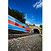 Fast train passing through a tunnel on a lovely summer day (motion blurred image)