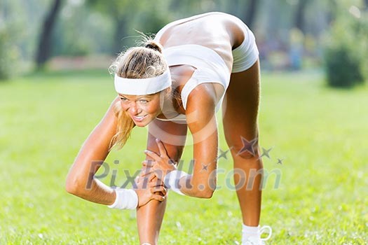 Young sport woman in white stretching in park Young sport woman in white stretching in park