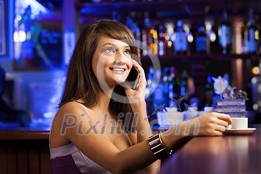 Young attractive lady at bar talking on phone Young attractive lady at bar talking on phone