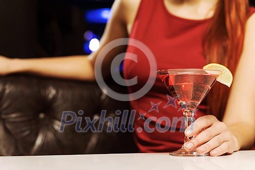 Close up of woman in red dress with cocktail in hands Close up of woman in red dress with cocktail in hands