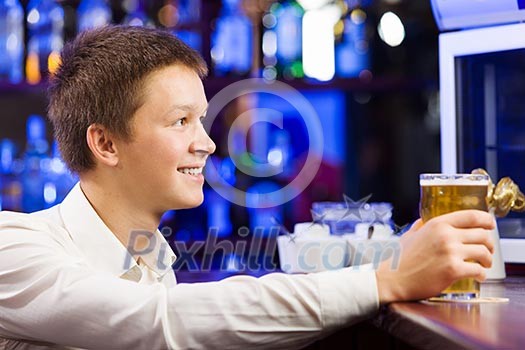 Young man in shirt sitting at bar Young man in shirt sitting at bar