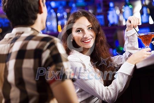 Young couple in bar having drinks and talking Young couple in bar having drinks and talking