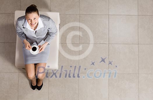 Top view of busineswoman sitting on chair with cup of coffee Top view of busineswoman sitting on chair with cup of coffee