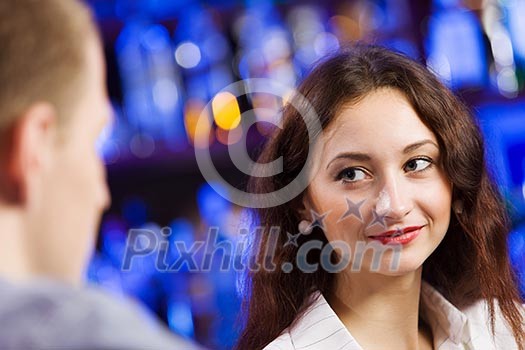 Young couple in bar having drinks and talking Young couple in bar having drinks and talking
