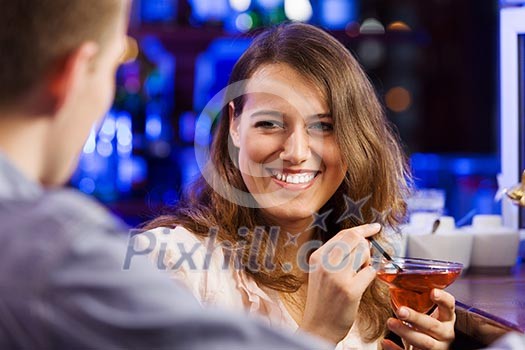 Young couple in bar having drinks and talking Young couple in bar having drinks and talking